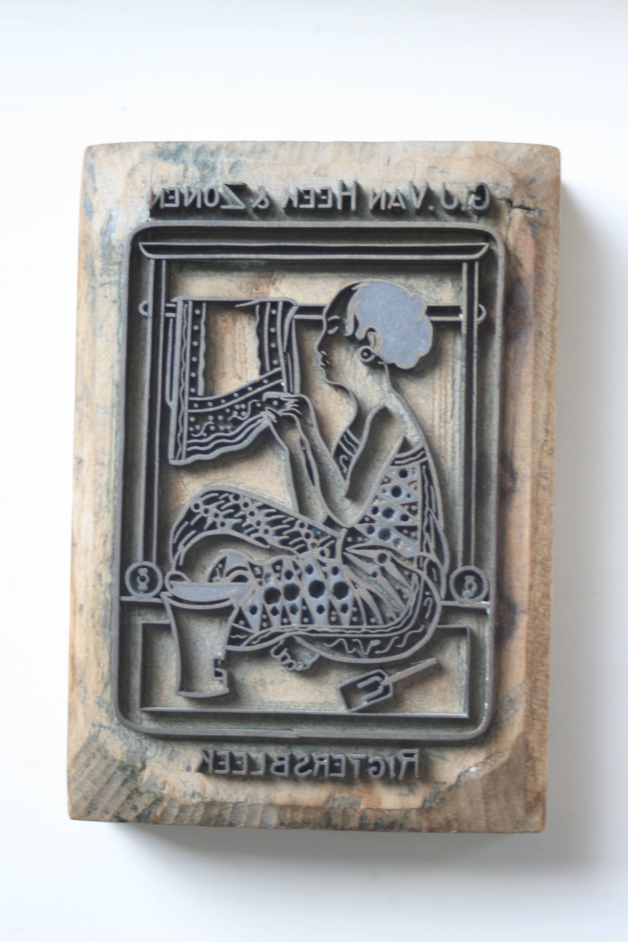 Het betreft hier een Tjap ,dat is het Indonesische woord voor stempel , de rollen katoen en Batikstoffen van Van Heek voor Indië werden met deze Tjap gemerkt ,een soort exportstempel.
